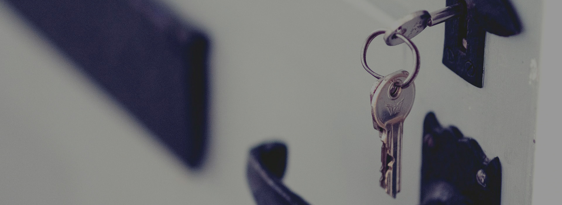 Keys hanging on door symbolizing secure real estate transactions and title search outsourcing US